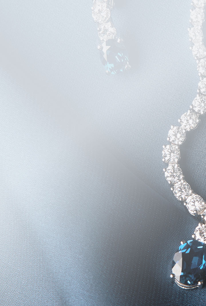 the edge of a diamond necklace with a blue sapphire pendant