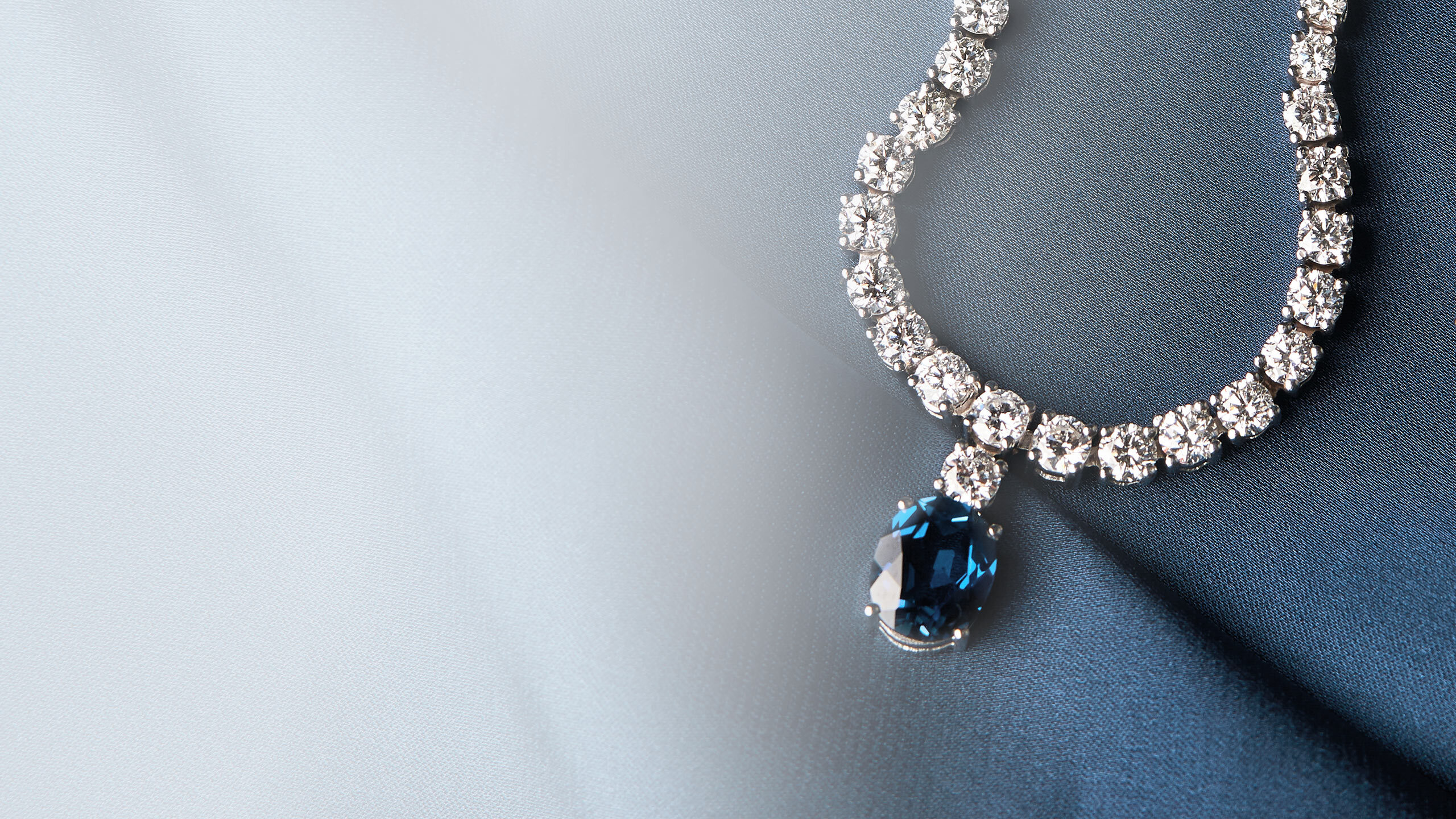 a diamond necklace with a blue sapphire pendant